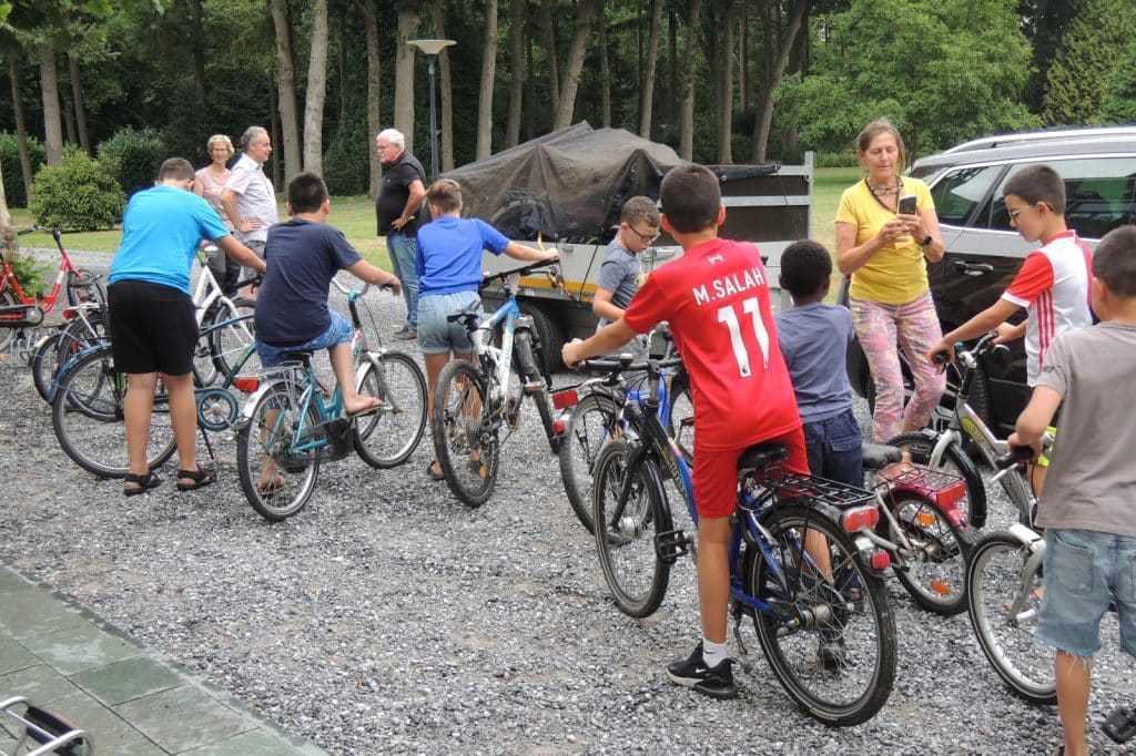 Kinderen zitten op geleende fietsen van Vindingrijk te wachten voor vertrek.