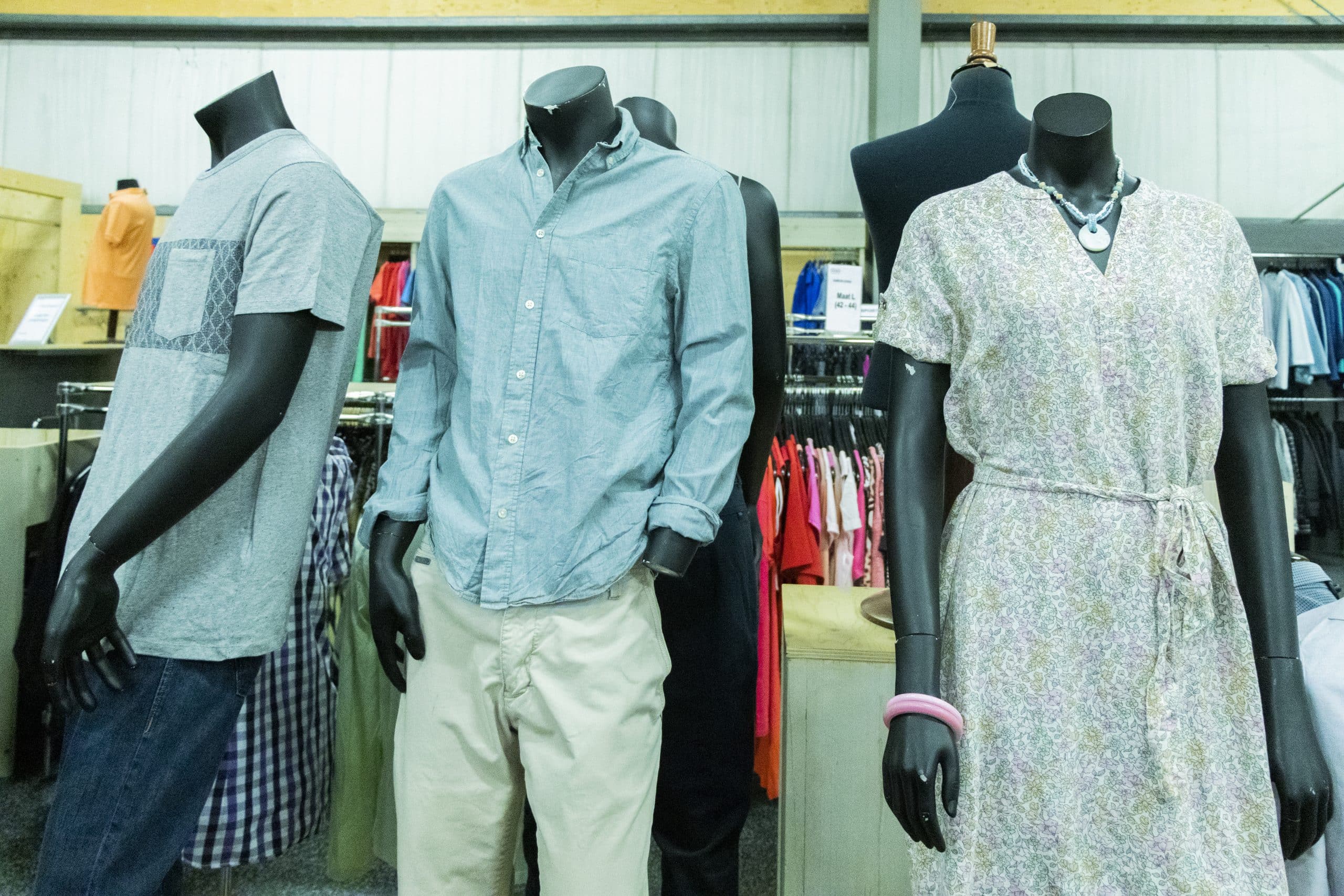 Op de foto zie je vijf paspoppen met zomerse kleding op onze textielafdeling.